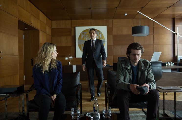 Annabel Richter (Rachel McAdams) közvetít Karpov és a bankár Tommy Brue (Willem Dafoe) között